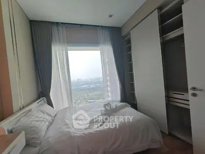 Cozy bedroom with stunning city view and ample closet space, perfect for urban living.