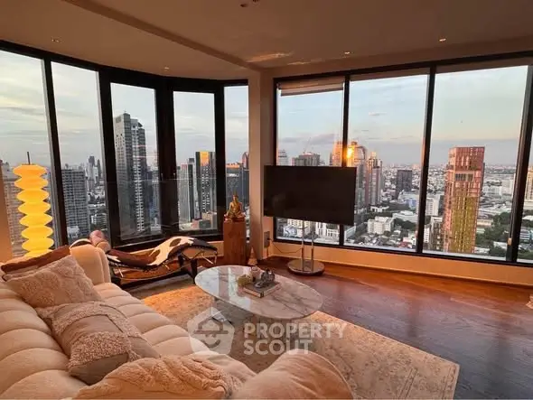 Luxurious living room with panoramic city views and modern decor in high-rise apartment.