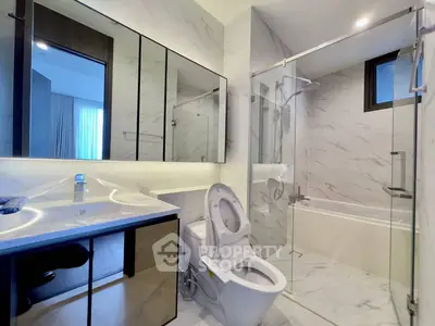 Modern bathroom with sleek design, glass shower, and marble finishes
