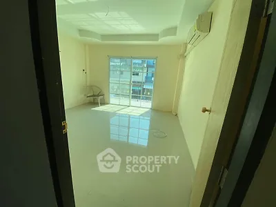 Bright empty room with large window and air conditioning, ideal for customization.