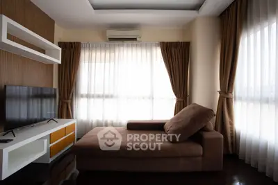 Modern living room with stylish sofa and large windows with curtains