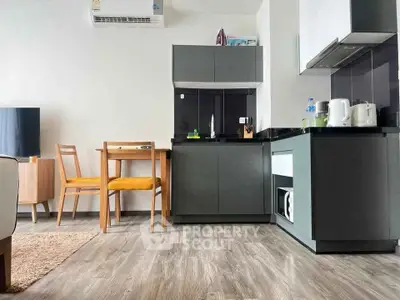 Modern kitchen with sleek cabinets and dining area in stylish apartment.
