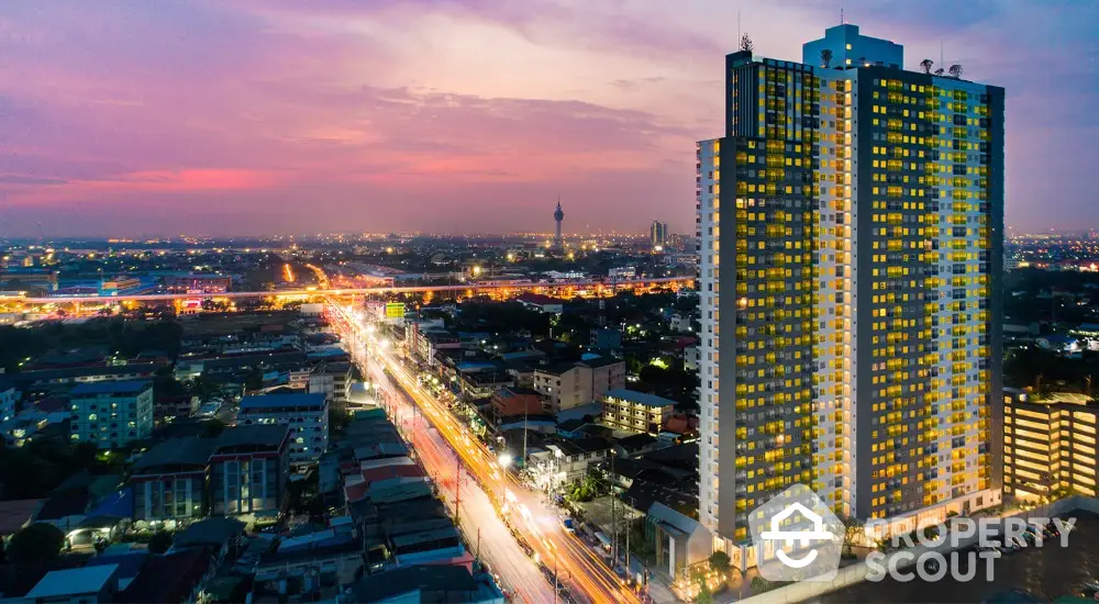 Stunning high-rise building with cityscape view at sunset, showcasing urban living and vibrant city lights.