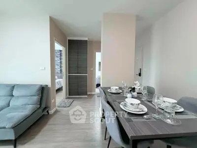 Modern dining area with elegant table setting and cozy living space in a stylish apartment.