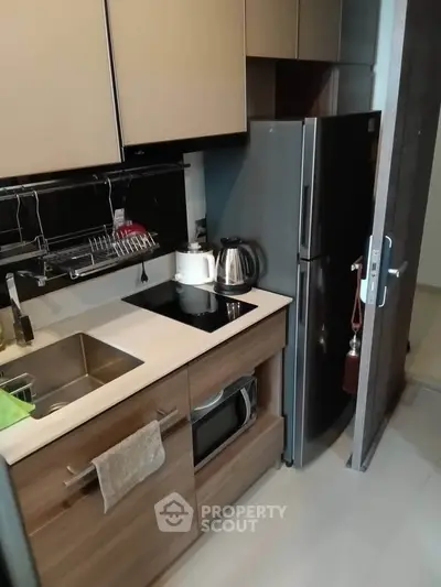 Modern compact kitchen with sleek appliances and wooden cabinetry