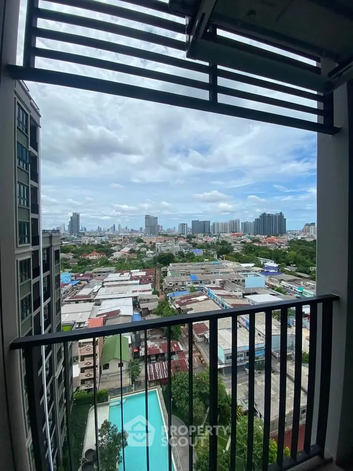 Stunning cityscape view from high-rise balcony overlooking urban skyline and pool.