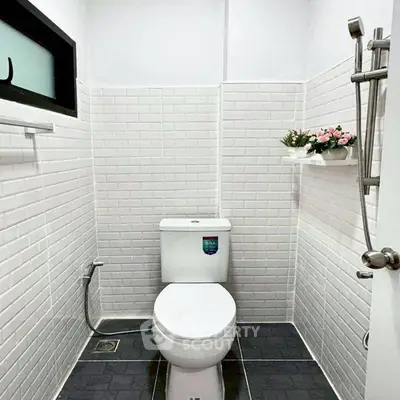 Modern minimalist bathroom with white subway tiles and sleek fixtures.