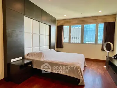 Spacious bedroom with modern design and large window offering natural light.