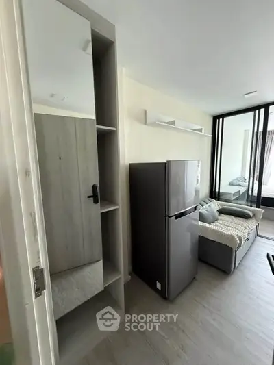 Modern apartment interior with sleek fridge and cozy living area