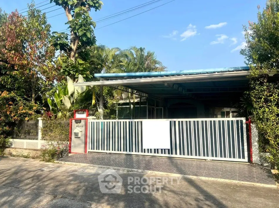 Charming single-story home with gated entrance and lush greenery, perfect for serene living.
