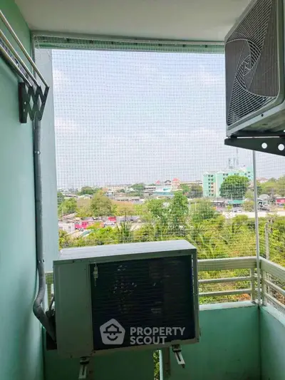 Charming balcony with air conditioning unit and scenic view of lush greenery and cityscape.