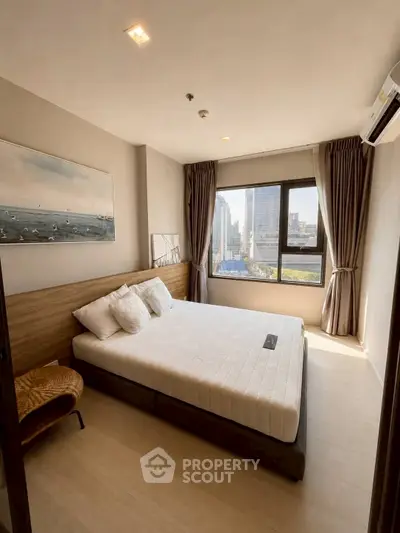 Modern bedroom with city view, featuring a comfortable bed and stylish decor in a high-rise apartment.