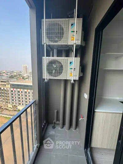 Modern balcony with city view and air conditioning units in a high-rise building.