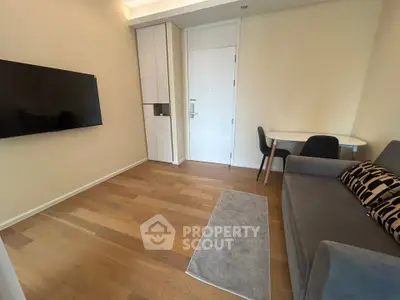Modern living room with sleek furniture and wall-mounted TV in a cozy apartment.