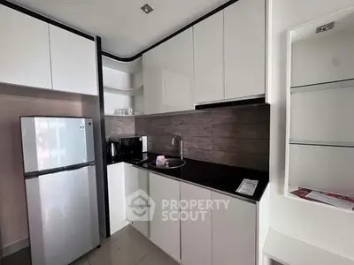 Modern kitchen with sleek cabinets and stainless steel appliances in a compact layout.