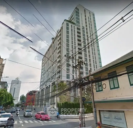 Modern high-rise building with urban street view, showcasing contemporary architecture in a bustling city environment.