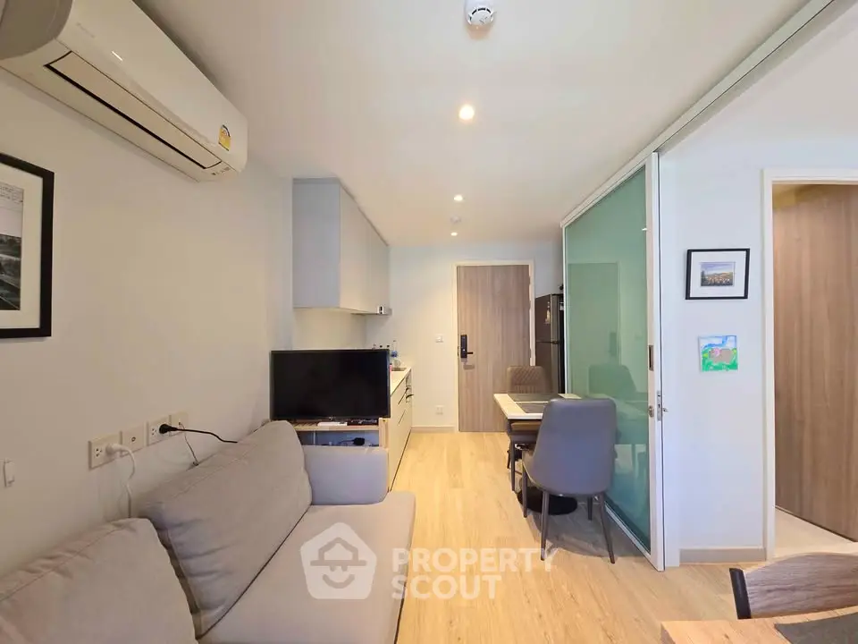 Modern living room with sleek furniture and open kitchen layout in a stylish apartment.