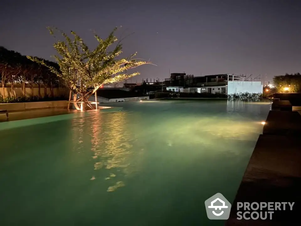 Serene night-time view of a luxurious pool area with ambient lighting, perfect for evening relaxation and social gatherings in a high-end residential complex.