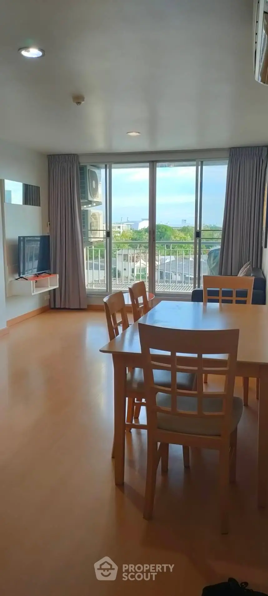 Spacious living room with dining area and balcony view in modern apartment