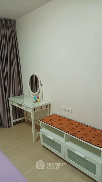 Modern bedroom with stylish vanity and storage bench, perfect for urban living.
