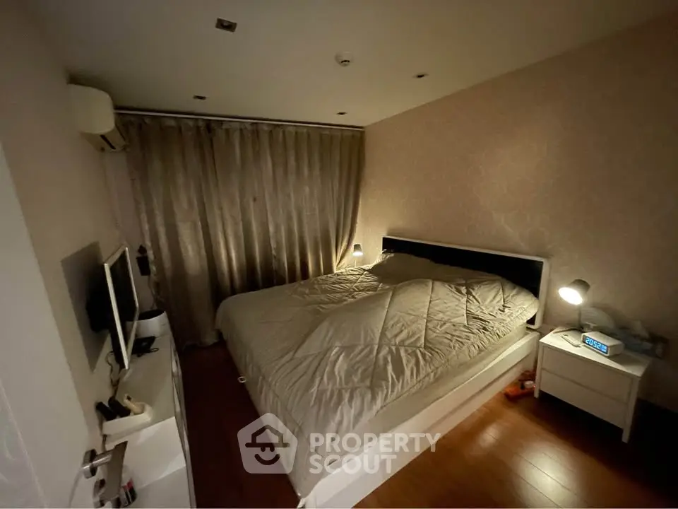 Cozy bedroom with elegant wallpaper and soft lighting, featuring a comfortable bed and modern decor.