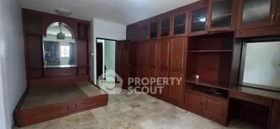 Spacious bedroom with built-in wooden wardrobe and cozy alcove bed