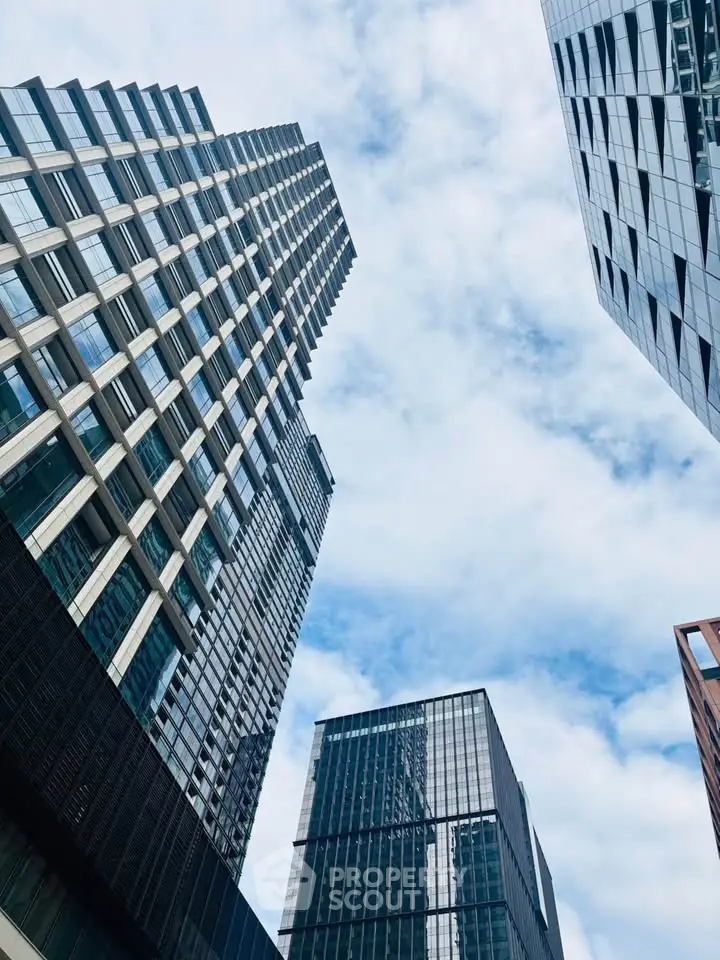 Stunning modern skyscrapers with glass facades against a bright blue sky, showcasing urban architectural elegance.