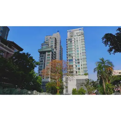 Stunning high-rise residential buildings with lush greenery and clear blue sky.