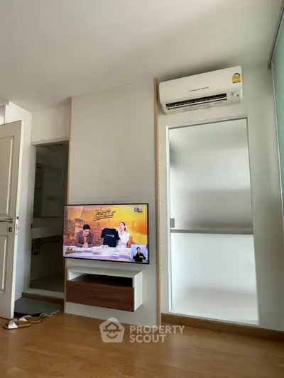Modern living room with wall-mounted TV and air conditioning unit