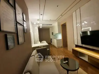 Modern living room with elegant decor and open kitchen layout, featuring cozy seating and stylish lighting.