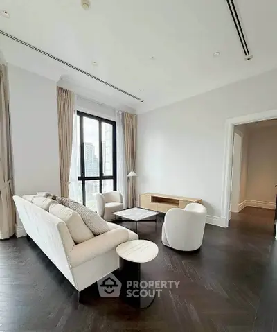 Elegant living room with modern furniture and city view, featuring high ceilings and natural light.