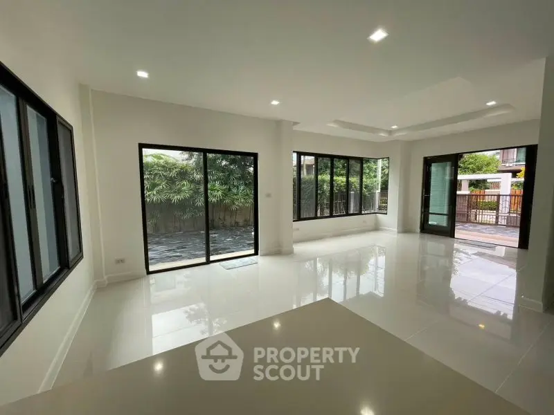 Spacious modern living room with large windows and garden view