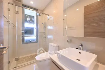 Modern bathroom with glass shower enclosure and sleek fixtures