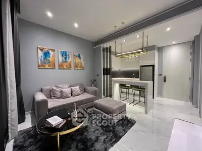 Modern living room with open kitchen, stylish decor, and cozy seating area.