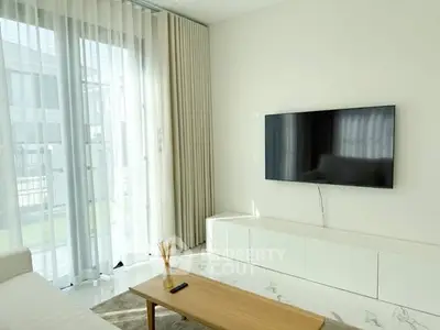 Modern living room with sleek TV setup and floor-to-ceiling windows