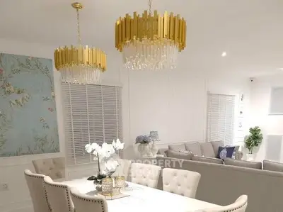 Elegant dining and living room with luxurious chandeliers and stylish decor