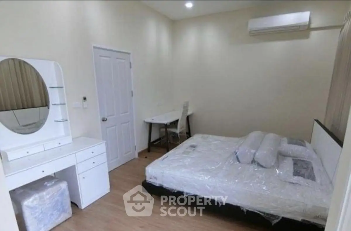 Spacious bedroom with modern furniture and air conditioning in a cozy apartment.