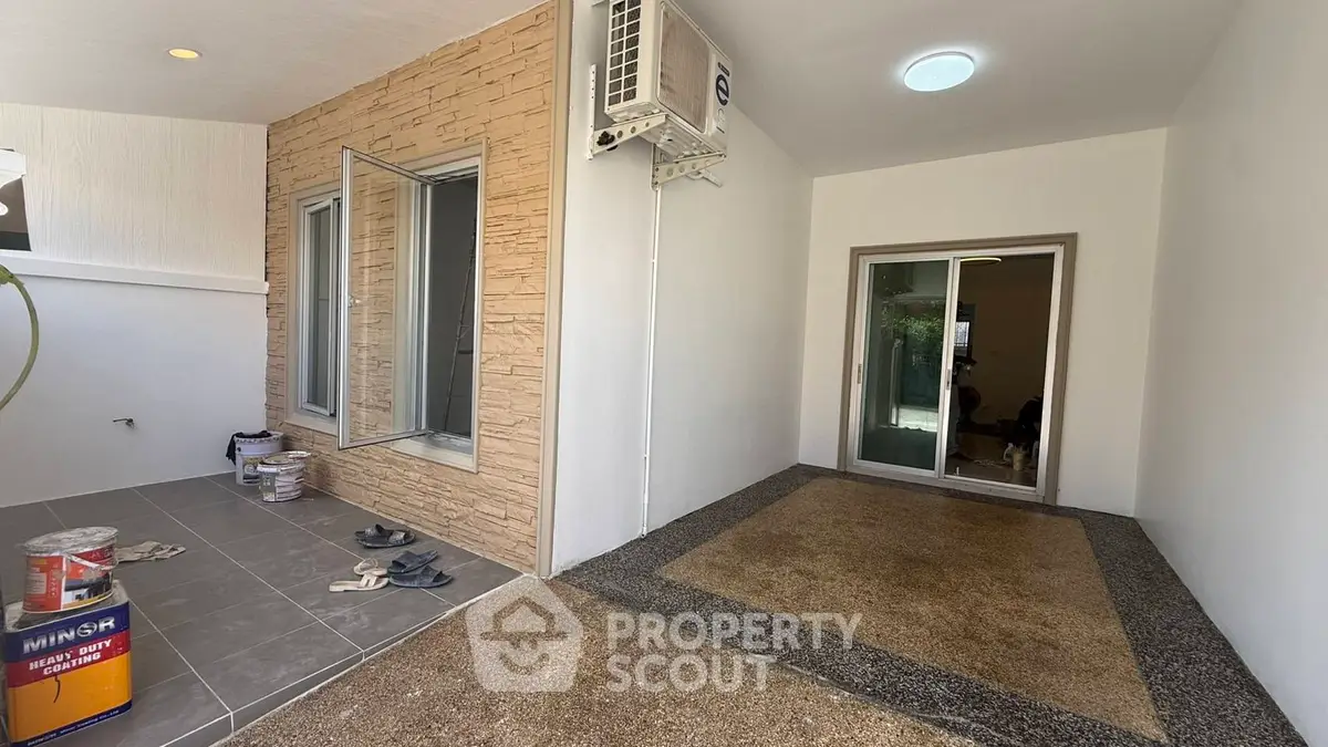 Modern home entrance with stone accent wall and sliding glass door