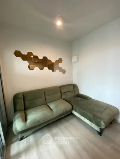 Stylish living room with modern green sofa and geometric wall art