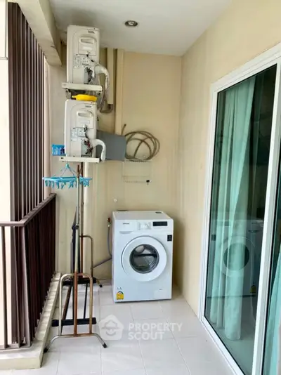 Compact balcony with washing machine and air conditioning units, ideal for urban living.