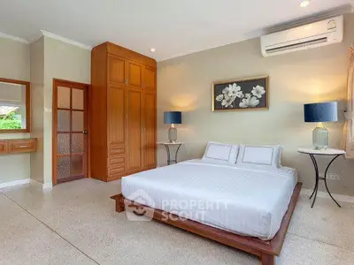 Spacious bedroom with modern decor and air conditioning in a stylish home.