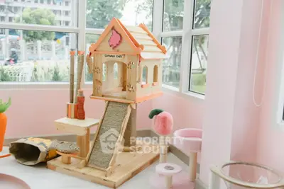 Charming pet-friendly room with custom cat playhouse and large windows.