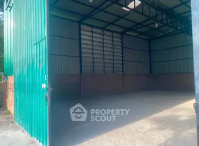 Spacious industrial warehouse with high ceilings and large entryway, perfect for storage or manufacturing needs.