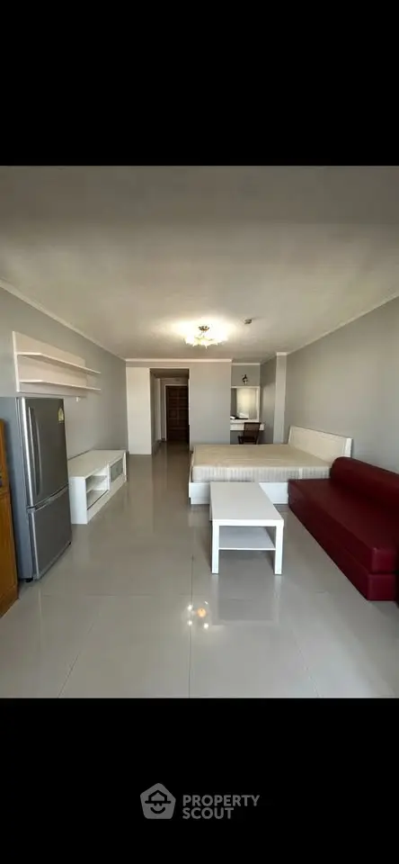 Spacious studio apartment with modern furnishings and open layout, featuring a cozy living area and sleek kitchen.