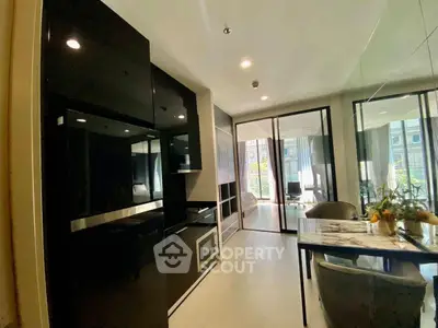 Modern kitchen with sleek black cabinets and dining area in luxury apartment