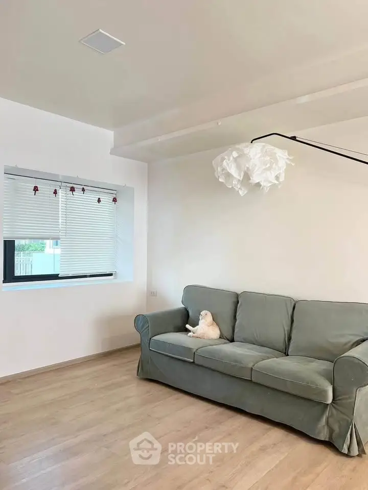Spacious living room with modern sofa and stylish lighting, perfect for relaxation.