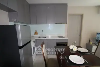 Modern kitchen with sleek cabinetry, integrated appliances, and dining area in a stylish apartment.