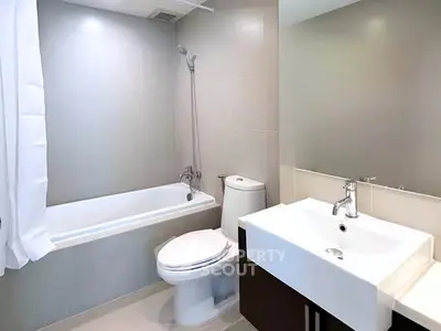 Modern bathroom with sleek fixtures and bathtub in a contemporary apartment.