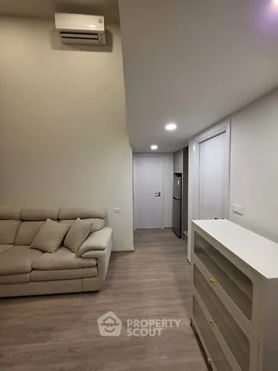 Modern living room with sleek design and neutral tones, featuring a comfortable sofa and stylish storage unit.
