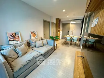 Modern living room with stylish decor and open dining area, featuring cozy seating and contemporary design.